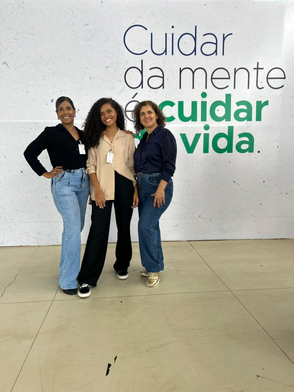 Equipe de psicólogas da Clínica Evoluir, clínica de psicologia em Porto Velho (RO), em frente ao painel “Cuidar da mente é cuidar da vida”